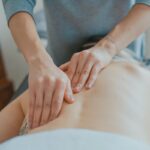 hands of a massage therapist kneading the spine